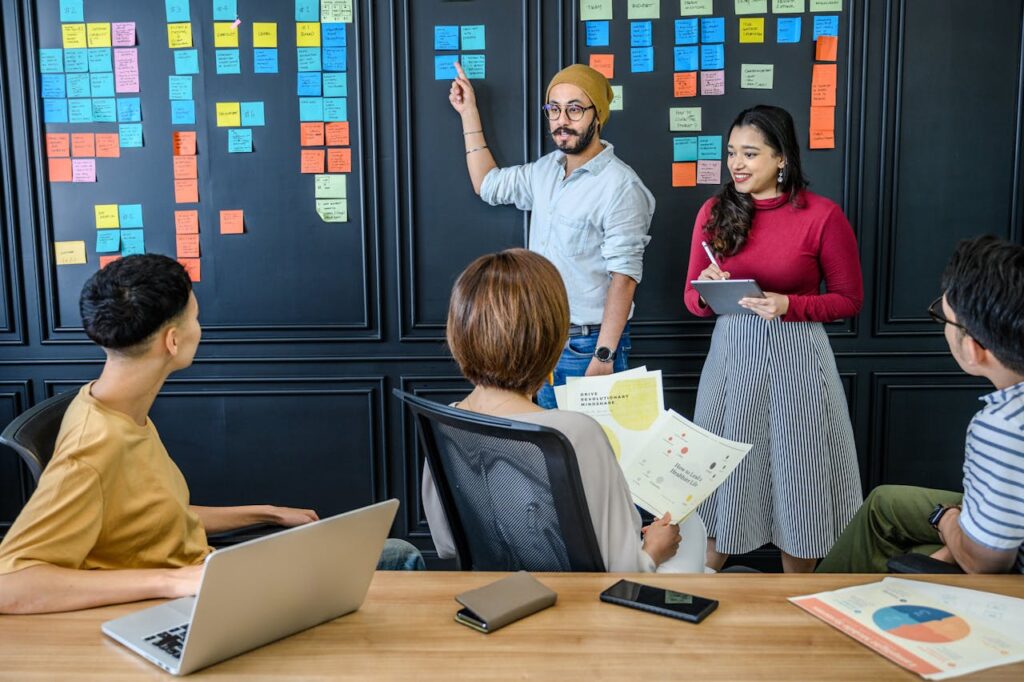 A diverse team collaborates on a project in an office, using sticky notes for brainstorming.